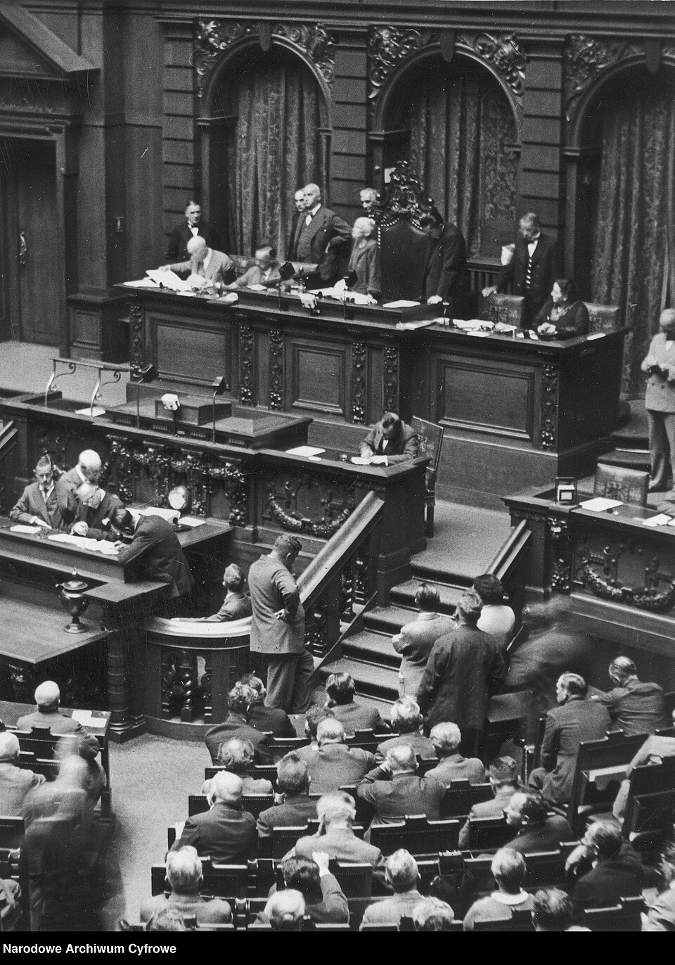 Zdjęcie ilustracyjne: 3 1 0 17 11954 4 1 32784 Opening of the Reichstag Session Eröffnung der Reichstagssitzung Berlin 1932-08-30 Assembly hall. In the Presidium, senior member of parliament Klara Zetkin is visible opening the session. NAC, Poland PD.jpg