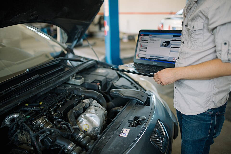 Zdjęcie ilustracyjne: Young mechanic with modern laptop doing car diagnostic at automobile repair.jpg