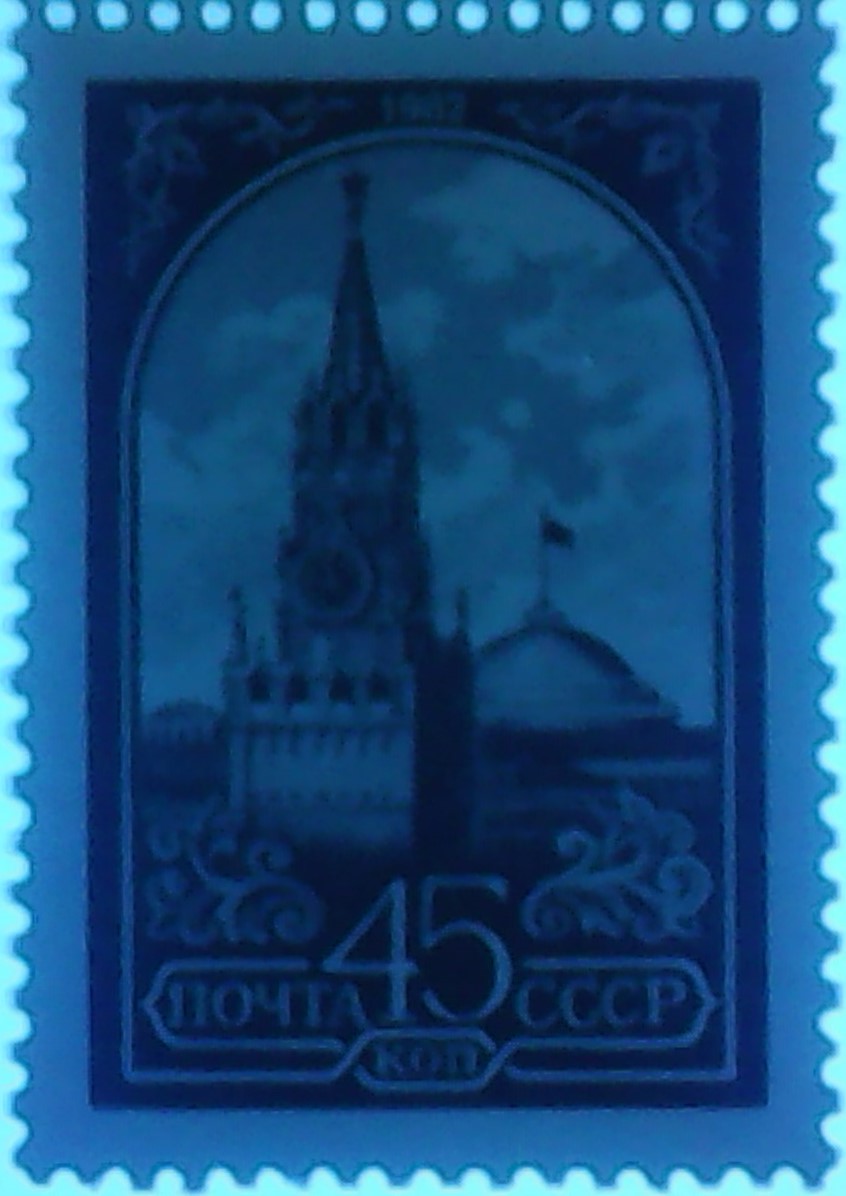 Zdjęcie ilustracyjne: The Soviet Union 1984 CPA 5510 stamp under 365nm UV on fluorescent background (13th standard issue of Soviet Union. 6th issue. Spasskaya Tower and the headquarters of the Council of Ministers).jpg